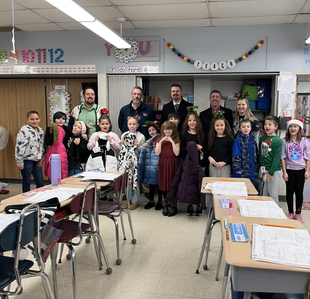 Students in Miss Stanek's third grade classroom hold new coats donated by the Greater Lehigh Valley REALTORS® and several members.